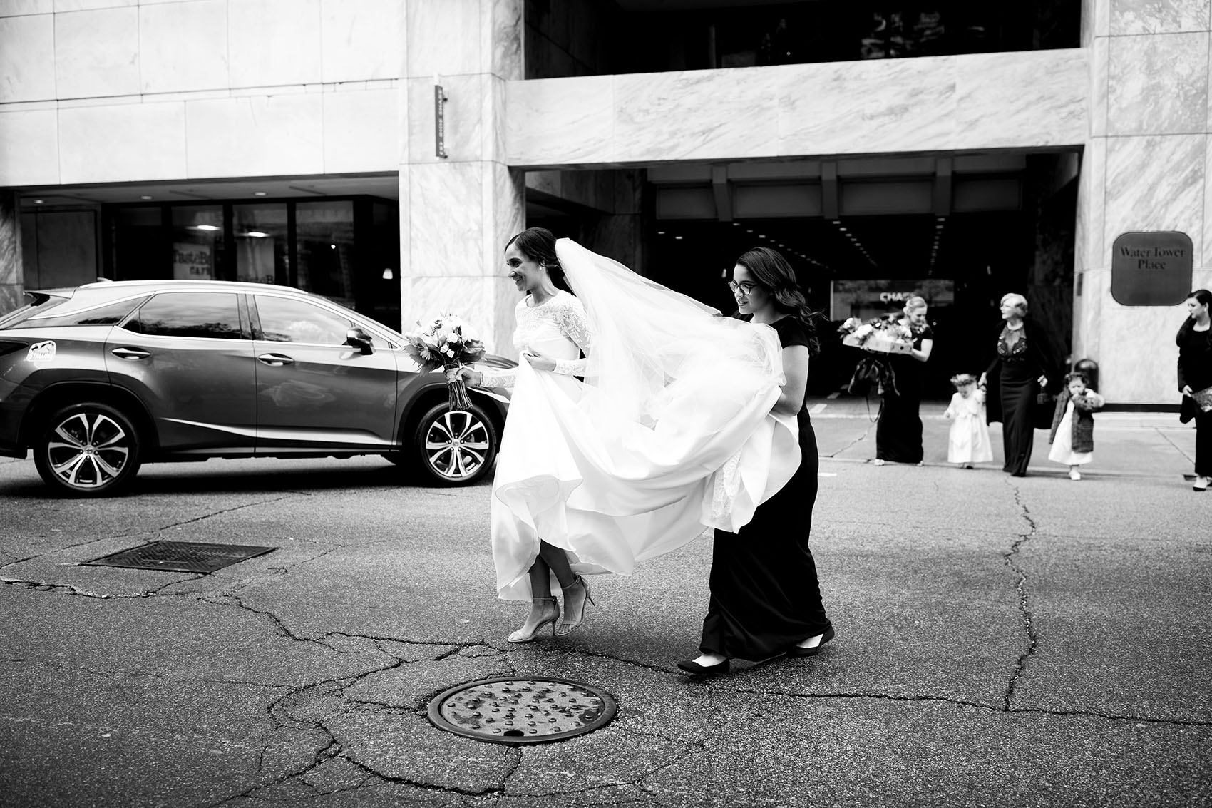 bride and sister walking across the street outside the ritz carlton